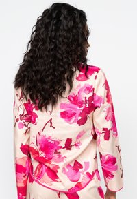 Blouse met lange mouwen van zachte stof met een groot roze bloempatroon op een crèmekleurige achtergrond. Inclusief een ronde zoom en een relaxte pasvorm.