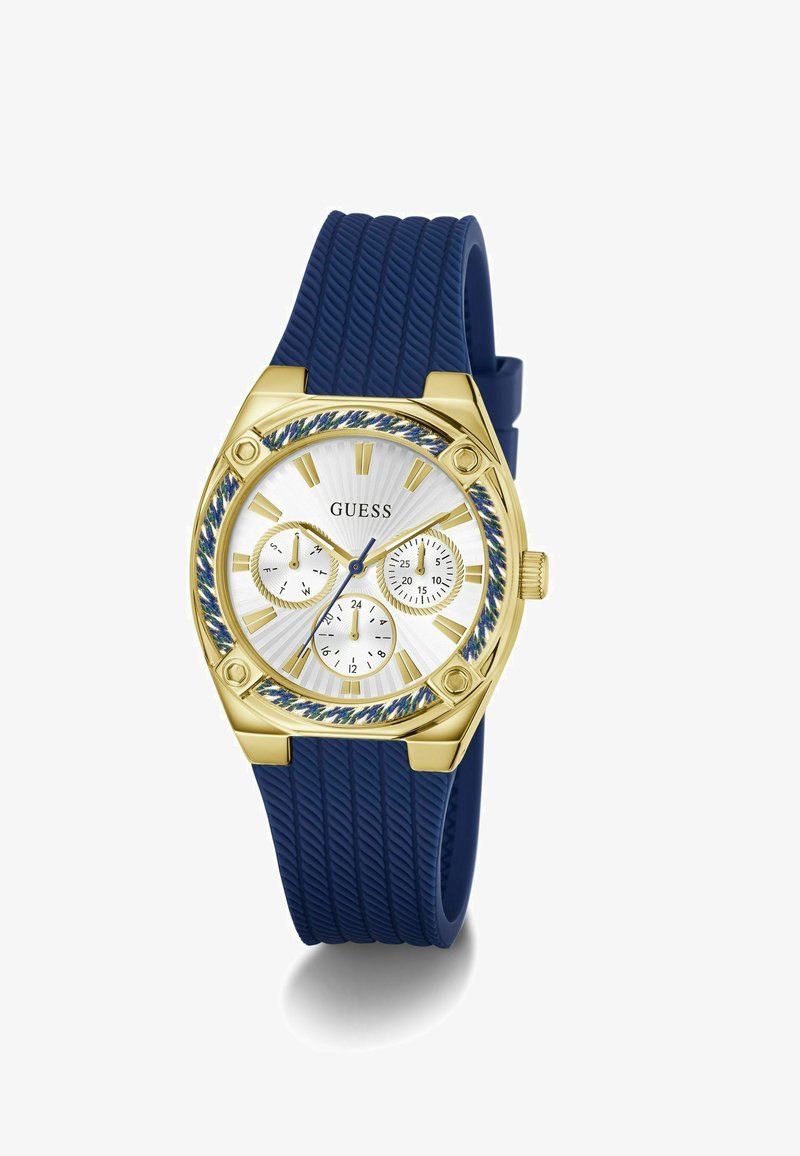 Goldene und blaue Guess-Armbanduhr mit blauem, strukturiertem Silikonarmband, weißem Zifferblatt, drei Hilfszifferblättern sowie goldenen Stundenmarkierungen und Zeigern.