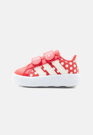 Sneaker rossa e bianca per bambino con pois, tre strisce bianche, due strisce in velcro e suola bianca spessa.