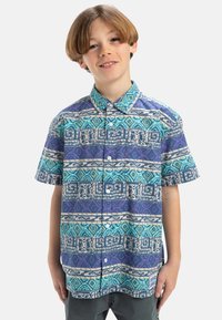 Korte mouwen overhemd met een blauw, paars en turquoise geometrisch patroon met contrasterende strepen en een klassieke kraag.
