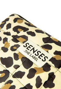 Quilted pouch in a leopard print pattern with beige, brown, and black colors. Features a textured surface and a white label with "SENSES" branding.