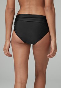Hochgeschnittener schwarzer Bikini-Unterteil aus weichem, glattem Stoff mit gerafften Details an der Taille und einem vollflächigen Schnitt hinten.