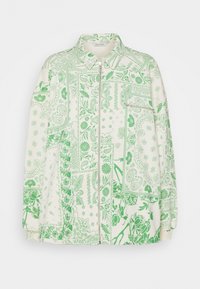 Giacca cream con zip, decorata con un motivo patchwork di fiori verdi e paisley, colletto e tasca con zip sul petto.