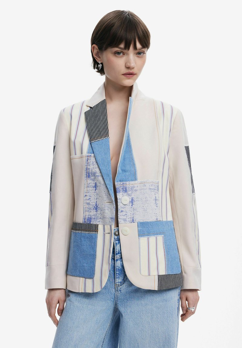 Patchwork blazer with varied denim and fabric panels in blue, white, and black stripes; two button closure and notched lapel design.