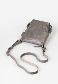 Borsa a tracolla in pelle grigia con superficie testurizzata, chiusura con zip superiore, tracolla regolabile e dettagli in metallo. Forma rettangolare compatta.