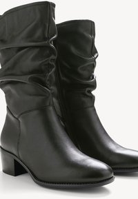 Botine din piele negre, până la jumătatea gambei, cu un șnur ușor căzut, vârf rotund, fermoar pe partea laterală și toc mic.