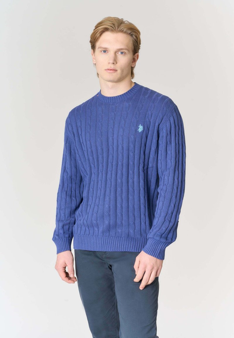 Maglione blu a trecce con collo tondo, polsini e orlo a coste, con un piccolo logo ricamato sul petto a sinistra.