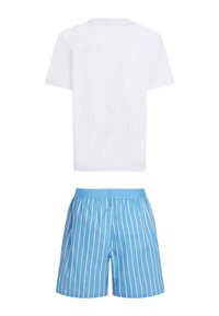 T-shirt blanc à manches courtes associé à un short bleu avec des rayures blanches verticales et une taille élastique.