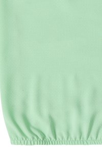 Tissu vert clair avec une texture subtilement pointillée et une couture élastique froncée au bord inférieur.