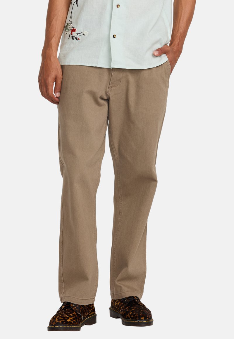 Beige cotton trousers with a straight-leg design, featuring side pockets and a smooth texture, paired with patterned shoes.