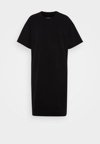 Vestido de algodón negro de corte oversize con cuello redondo, mangas cortas y detalle del logotipo en relieve. Diseño de corte recto con dobladillo a la altura de la rodilla.