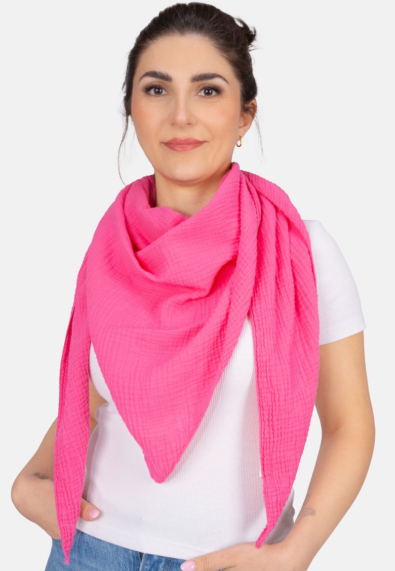 Écharpe rose vif en tissu léger et texturé, stylisée en forme triangulaire, avec un drapage décontracté autour du cou.