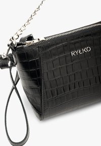 Borsa a tracolla in pelle nera con texture a coccodrillo, caratterizzata da una cerniera argentata, una tracolla a catena e un logo sul davanti. Forma compatta e rettangolare.