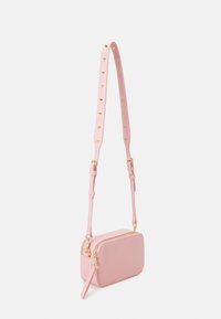 Różowa skórzana torebka na ramię ze złotymi okuciami. Charakteryzuje się prostokątnym kształtem, regulowanym paskiem i gładką fakturą z zamkiem błyskawicznym.