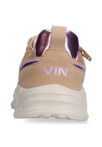 Beige sneaker with a textured suede upper and shiny purple accents, featuring a padded back and white rubber sole. "VIN" logo displayed.