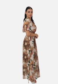 Robe maxi en tissu léger avec un motif floral dans des tons de marron et de rose doux. Dotée de manches courtes, d'une taille cintrée et d'un design fluide.