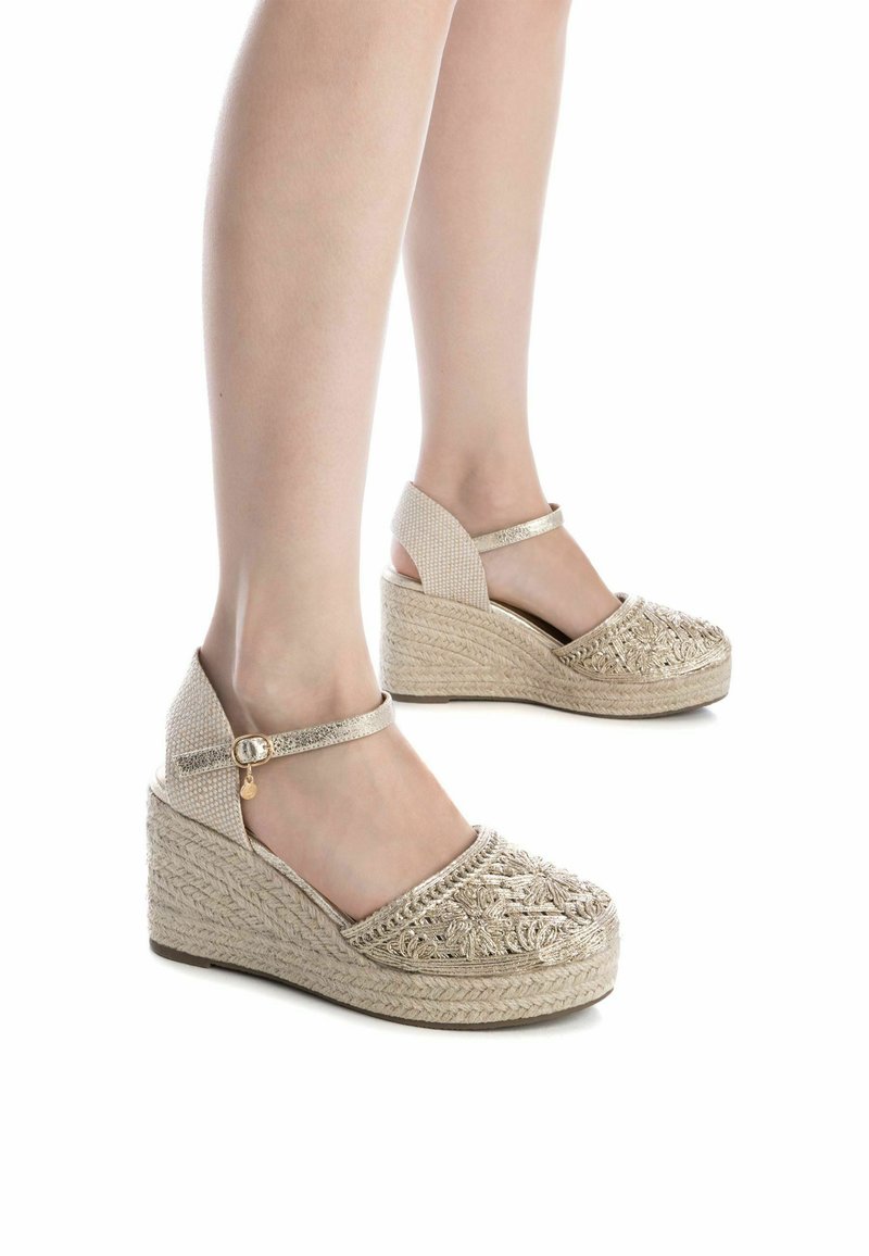 Sandali wedge beige con tomaia in tessuto testurizzato, cinturino alla caviglia regolabile e parte anteriore riccamente ricamata. Suola in juta stile espadrilles.