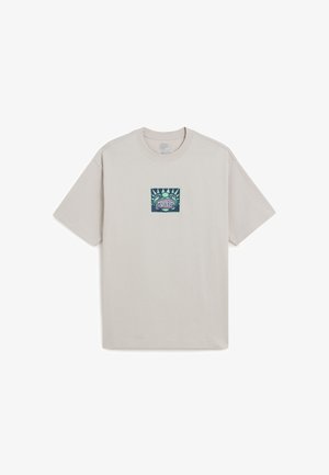Camiseta de manga corta gris claro con un pequeño gráfico central de una cara de rana estilizada en verde con texto en sus dientes.