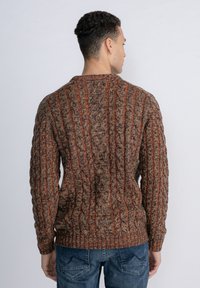 Brown cable-knit sweater with orange accents, featuring a ribbed neck and cuffs, structured fit, and textured pattern.