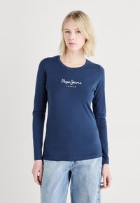Langsleeve marineblauw shirt van katoen met een ronde hals en wit logo "Pepe Jeans London" op de borst. Vloeibare textuur.