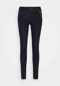 Pantalones de mezclilla azul oscuro con un corte ajustado, que presentan un detalle de bolsillo con cremallera, textura suave, cierre de botón y diseño de cintura alta.