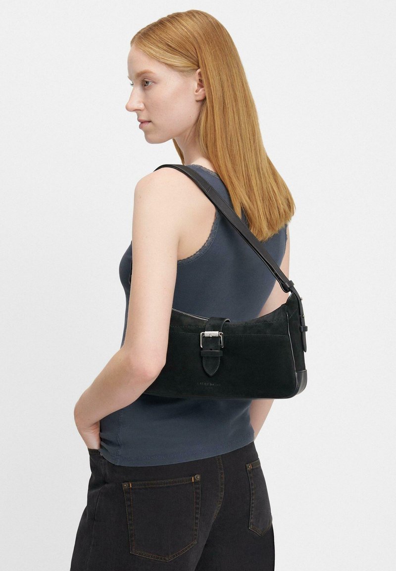 Borsa a tracolla nera in suede con fondo in pelle liscia e dettaglio con fibbia, dotata di chiusura con zip e una lunga tracolla regolabile.