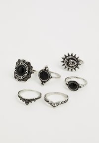 Set av sex ringar i silverfärgad metall. Designen inkluderar sol- och dekorativa mönster med svarta stenar som detaljer. Olika former och stilar.
