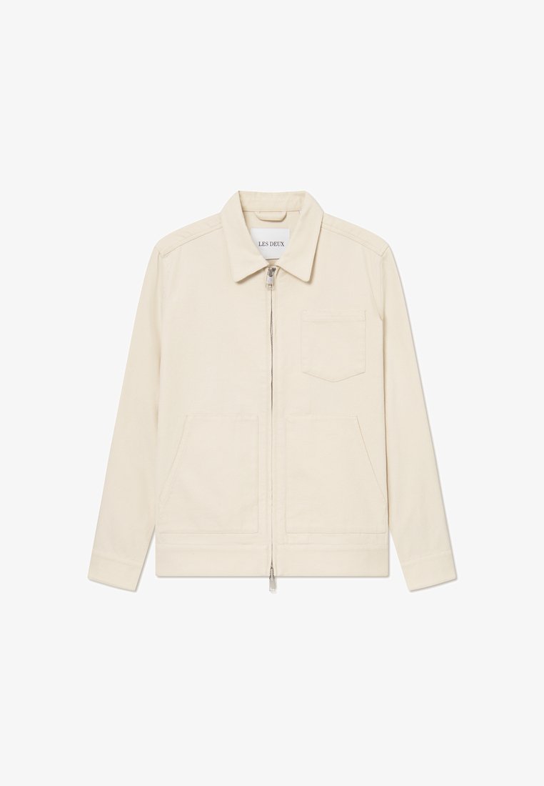 Beige cotton jacket featuring a zip front, a classic collar, two front pockets, and a left chest pocket. Smooth texture with subtle stitching.