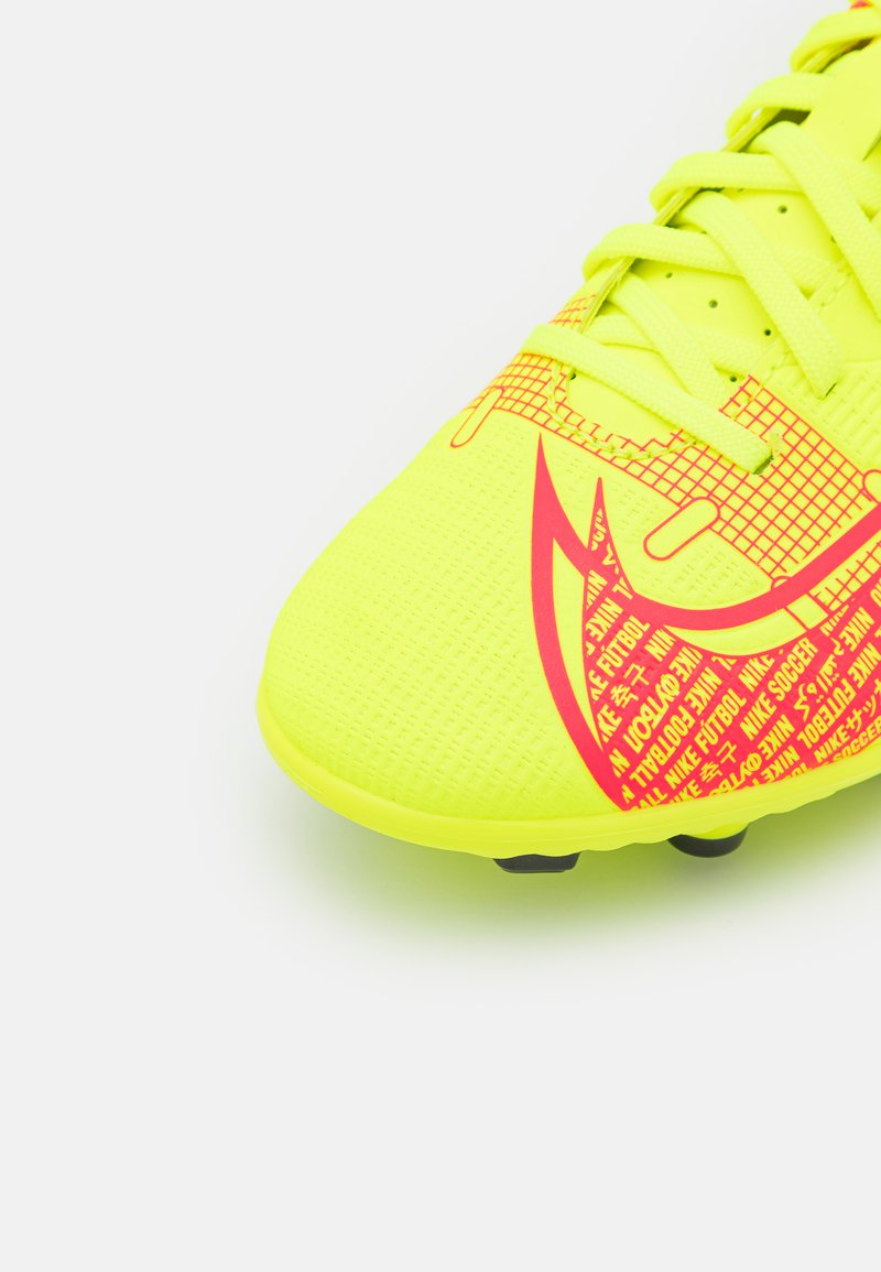 Crampon de football jaune vif avec une tige texturée et le logo Nike rose. Dispose d'un bout arrondi et de crampons noirs pour l'adhérence.