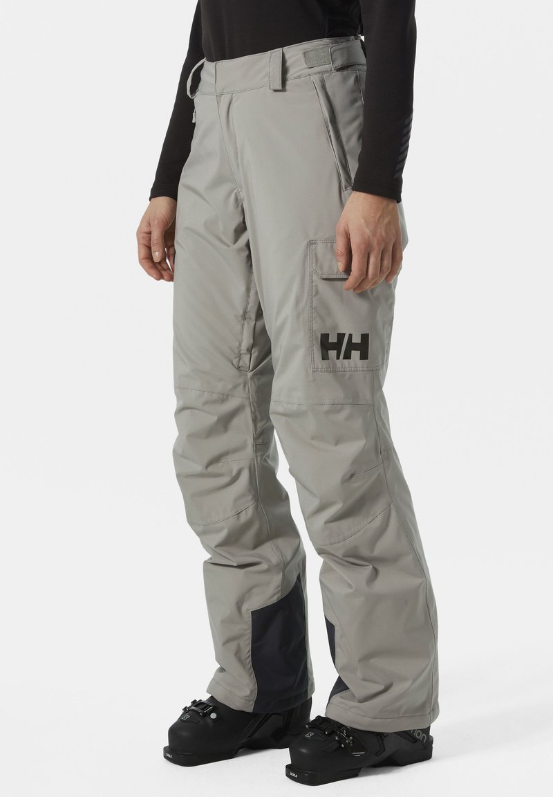 Grau Skihosen mit geradem Schnitt, Cargo-Tasche und schwarzem Logo. Merkmale sind Kontrastpaneele und ein verstärkter Saum für Langlebigkeit.