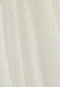 Tela blanca transparente con sutiles patrones florales bordados que crean un diseño texturizado delicado sobre una superficie blanda y fluida.