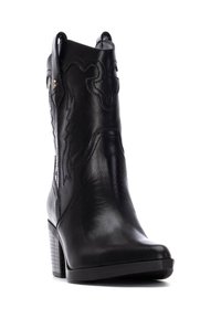 Stivale da cowboy in pelle nera con cuciture intricate. Presenta una punta affusolata, un tacco impilato e linguette sui lati per una facile calzata.