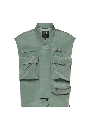 Light green sleeveless utility vest with multiple front pockets, zipper detail, and Oakley brand label on the upper chest pocket.
