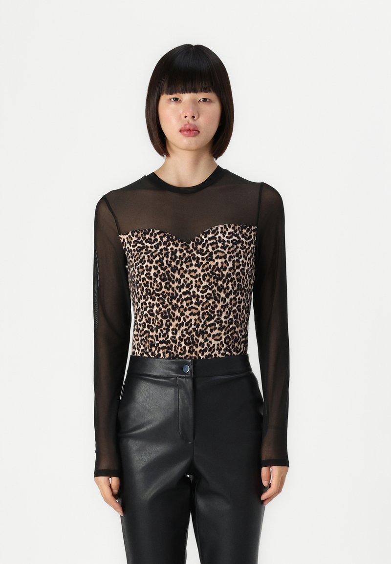 Felpa a maniche lunghe con sovrapposizione trasparente nera e un corpetto con stampa leopardata a scollo a cuore. Abbinata a pantaloni in pelle nera.