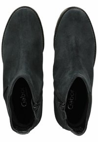 Las botas de tobillo de ante negro presentan una textura suave, una punta redondeada y cremalleras laterales para facilitar su uso. El interior tiene una plantilla con la marca.