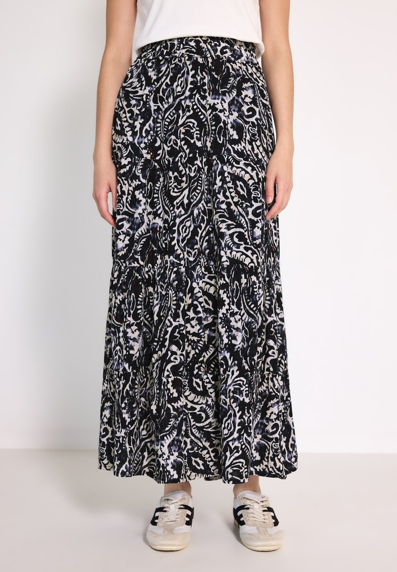Černá maxi sukně s bílým a modrým paisley vzorem, vyrobená z lehkého materiálu. Elastický pas a volánkový design. Kombinováno s teniskami.