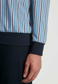 Gestreifter Pullover in Blau, Orange und Weiß. Verfügt über einen gerippten navyfarbigen Bund und Saum, aus weichem Material mit lässiger Passform.