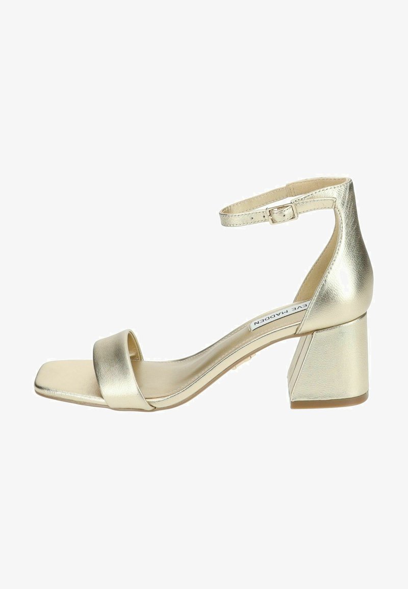 Sandali con tacco dorati metallici, con punta quadrata, sottile cinturino alla caviglia e un ampio tacco a blocco. Texture liscia e design minimalista.
