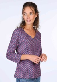 Langärmlige blaue Bluse mit V-Ausschnitt, geziert von einem sich wiederholenden Muster aus roten und pinken Bögen. Weicher Stoff mit lockerer Passform.