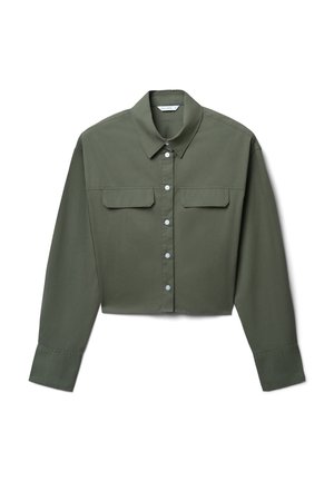 Camicia corta verde oliva con bottoni, maniche lunghe, colletto a punta e due tasche sul petto, adagiata su uno sfondo bianco.