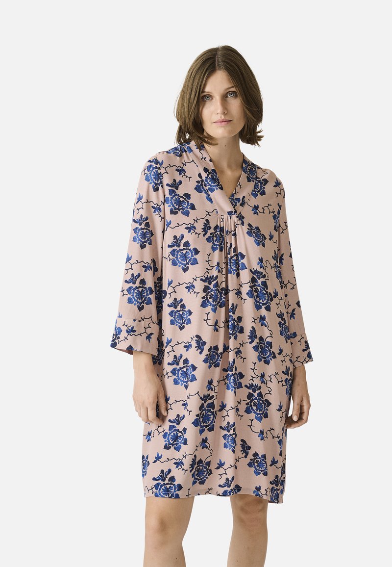 Rochie florală cu un fundal roz și flori albastre, decolteu în V și mâneci trei sferturi. Material ușor, cu detalii plisate.