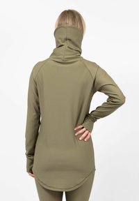 Olive green long-sleeve top with a high collar, ribbed texture, and a curved hem. Features fitted sleeves with thumbholes.
