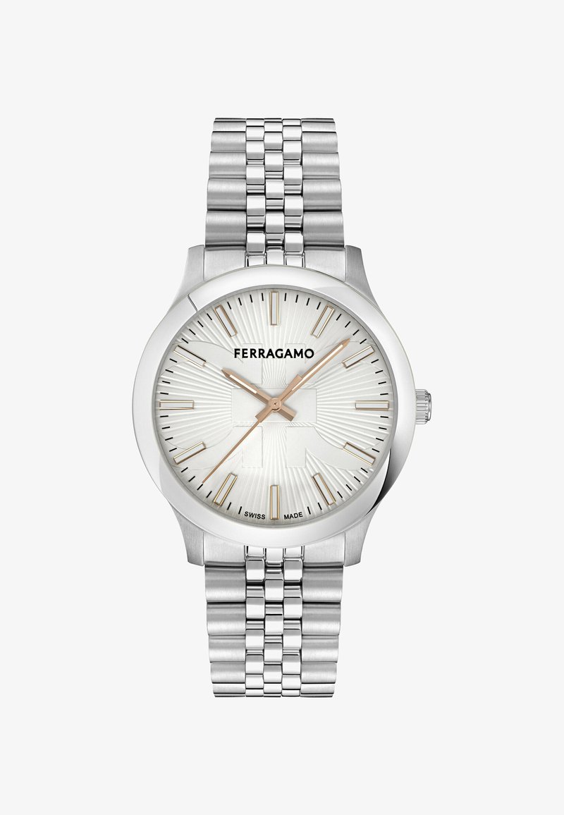 Ασημένιο ρολόι χειρός Ferragamo με ραβδωτό λευκό καντράν, χρυσούς δείκτες και αριθμούς ώρας, και πολυάγρευτη μεταλλική βέρα.