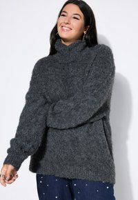 Dunkelgrauer, übergroßer Rollkragenpullover mit flauschiger Textur und langen Ärmeln, der eine lockere Passform und ein geripptes Bundabschlussdesign aufweist.