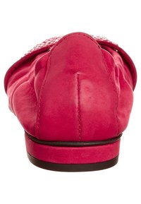 Mocassins en cuir rose vif avec une texture lisse, un bout rond et un profil bas. Présentent des coutures décoratives et une discrète bordure noire le long de la semelle.