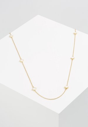Collier délicat en chaîne d'or avec de petits maillons en forme de cœur espacés régulièrement, présenté sur une plateforme géométrique blanche.