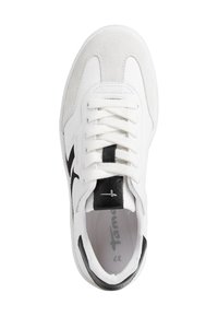 Basket blanche avec des accents en daim, logo noir et détails texturés, présentant un bout rond et des lacets plats. Doublure intérieure visible en gris.
