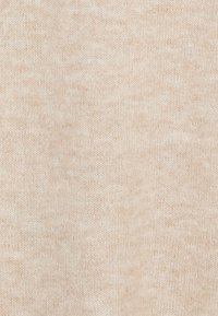 Tessuto a maglia beige con una finitura morbida e testurizzata. Il materiale appare fine e leggermente melangiato, offrendo una variazione sottile nel colore.
