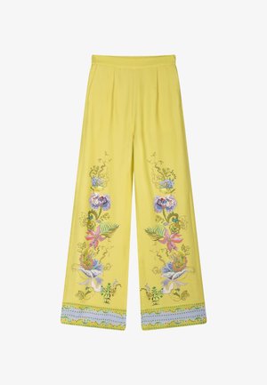 Gele broek met wijde pijpen, met kleurrijke bloemmotieven langs de buitenste pijpen en een decoratieve rand bij de zoom.