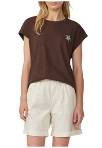 Brown short-sleeve t-shirt with a relaxed fit, featuring a small embroidered design. Paired with light beige, rolled hem shorts.